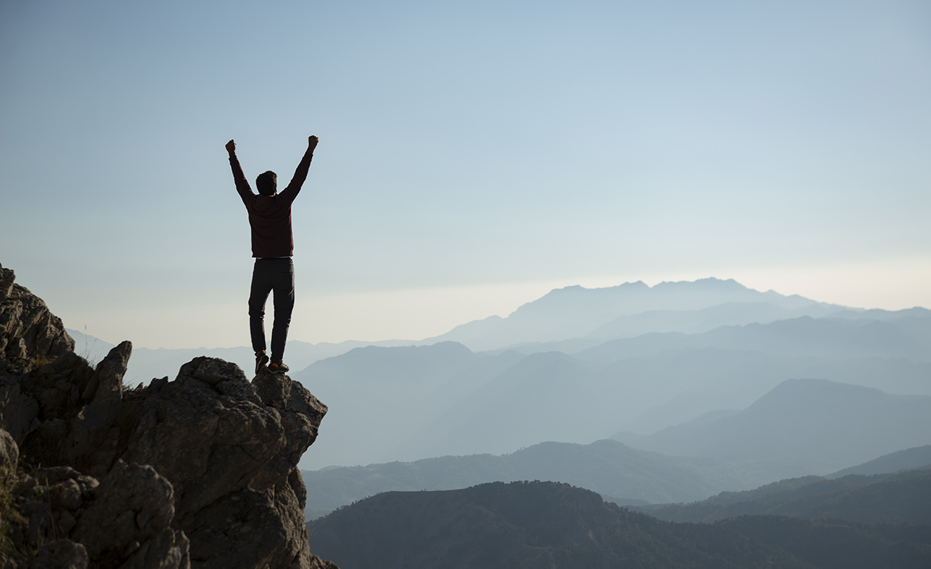 Image showing an elated man standing at the edge of a cliff looking at the beautiful view