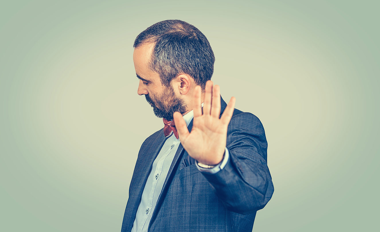 Man shown with hand up saying 'stop!'