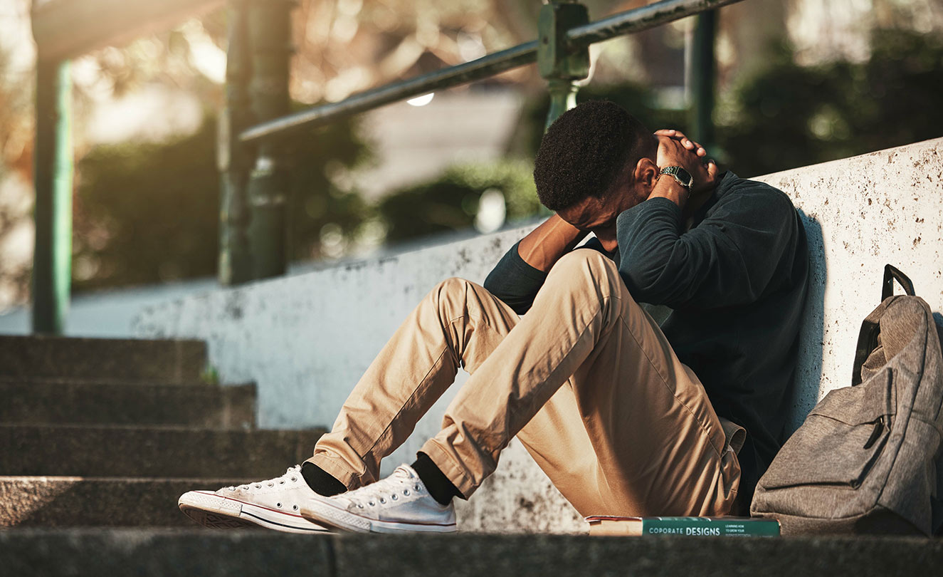 Man sitting with head down on knees