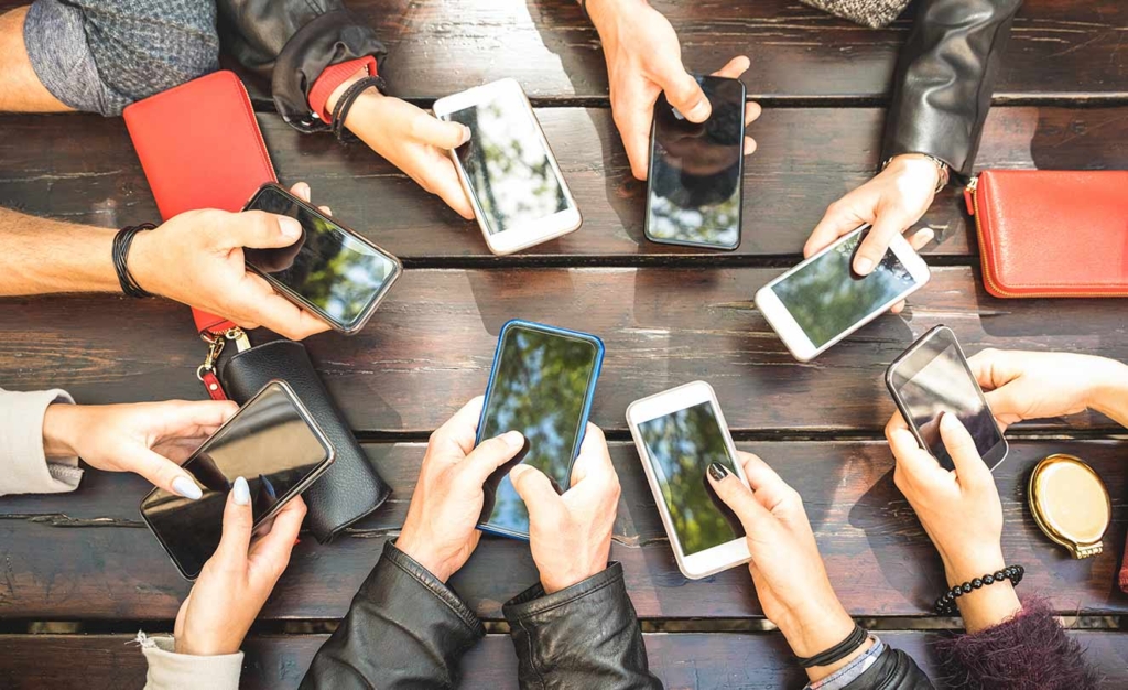 Several hands holding cell phones